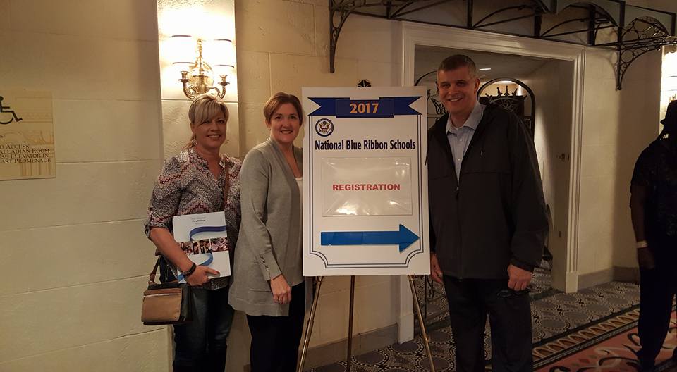 educators posing with blue ribbon award